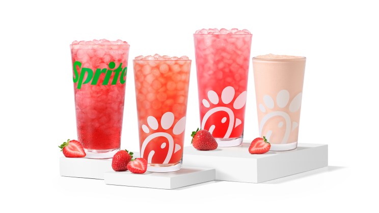 Four Chick-fil-A Strawberry Hibiscus beverages sitting on risers with a white background.
