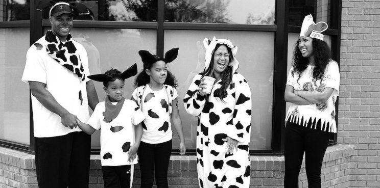 Chick-fil-A Guests dressed as cows standing outside a restaurant.